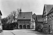 Die Westseite der Torhalle vor der Restaurierung: Im Vordergrund Gebäude Lorschs, im Hintergrund der Kirchenrest.