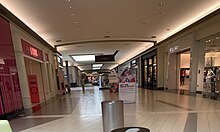 The concourse of a shopping mall, showing several of its storefronts.