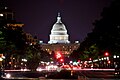 The U.S. Capitol Building lit up at night with the streets of Washington D.C.