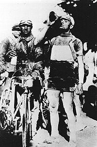 Italian cyclist Alfredo Binda drinking next to his bike