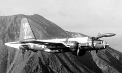 Plane in flight, with a mountain in the background