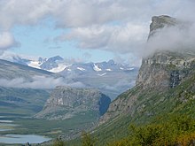 La montagne Skierffe légèrement entourée de nuages présente un à-pic très important.