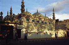 Bâtiment avec des coupoles et des minarets, photographié depuis une rue.