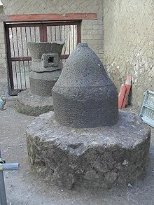 cylindre de pierre grise d'extrémité en cône, sur un massif de maçonnerie