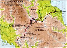 A map with Japanese and English characters on it, depicting the withdrawal of Japanese forces north over the Owen Stanley Range along the Kokoda Track. The route of the Japanese withdrawal is shown in black dotted arrows, while the advance of the Australian forces that followed them up is shown in red