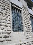 Rusticated masonry and Mamluk architecture-inspired wrought iron window grille