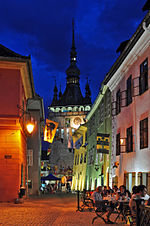 Town street in the evening. Old houses and a tower with a spire