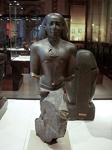 Statue de Iâhmessaneith, chef de la Cour de Justice. Grauwacke, H. 43 cm. Louvre[3]