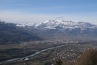 View of Triesenberg looking downstream at the municipality of Schaan in Liechtenstein over the Alpine Rhine to the municipalities of Buchs SG, Grabs and Gams SG and the snow-covered mountains of the Alpstein.