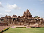 Stone structure decorated with columns, reliefs and sculptures and a high roof about the central part.