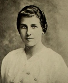 A yearbook photo of a young white woman with dark hair, wearing a white blouse