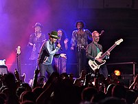 Jamiroquai performing on a stage in Bulgaria with purple lights
