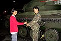 The first signs of support. A teenager hands a rose to a soldier at a M41 Walker Bulldog light tank.