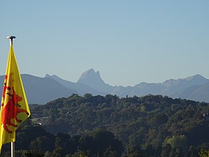 photographie en couleurs d'un drapeau représentant deux vaches rouges sur fond jaune.