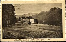 Historische Ansichtskarte des verschneiten Hochalpinen Töchterinstituts Fetan, im Vordergrund rechts neben dem Gebäude sieht man den Eisplatz, der den Damen das Eislaufen im Winter ermöglichte