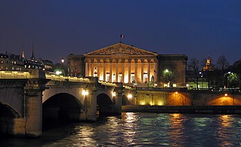 Vue de nuit du palais Bourbon, siège de l’Assemblée nationale, face à la Seine qu’enjambe le pont de la Concorde, et en arrière-plan le dôme des Invalides, à Paris (France). (définition réelle 2 082 × 1 269*)