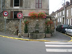 Fontaine, à l'angle nord de la rue de la Gare et de la rue du Montcel.