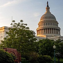 A photo of the United States Capitol, with a sunrise in the background.
