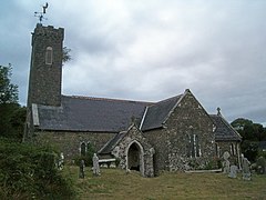 stone church with slate roof and slender tower