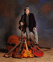 Dave Pomeroy and 5 of his many basses