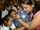 Children hug the 'calm lotus' sculpture to hear musical passages that create calm, 2014