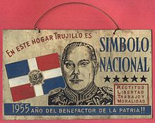 A metal sing with an engraving of Trujillo and the text "En este hogar Trujillo es simbolo [sic] nacional".