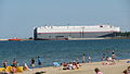 Car carrier in the entrance to the inner port, as seen from the nearby beach