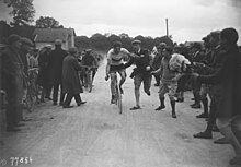 Photographie du coureur à l'arrivée, salué par la foule.