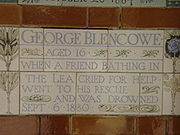 A tablet formed of five tiles of varying sizes, bordered by yellow and blue flowers in an art nouveau style