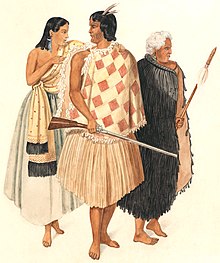 an image showing three people; from left to right, a woman wearing a long dress with her arms bear, a man with a feather in his hair and wearing a light coloured cloak and holding a rifle in one hand, and an older man with white hair and in a dark cloak holding a wooden spear