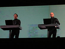 Kraftwerk performing onstage, standing on two separate dais.