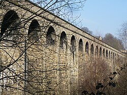 A stone viaduct viewed at an angle looking up