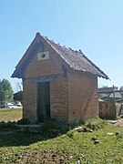 Photographie en couleurs d'une petite maisonnette en brique.