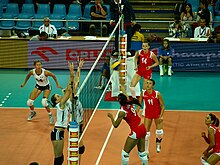 Partida do Campeonato Europeu de Voleibol Feminino de 2009 entre Turquia e França na Hala Stulecia em Wrocław, Polônia. Turquia está de uniforme vermelho e frança branco, é uma partida de vôlei