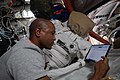 Victor reading blueprint information on an iPad inside the Quest Airlock, in prep for his spacewalk