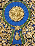 A woodcarving of "Maha Surabhorn", the Knight Grand Cross (First Class) of the Order of the Crown of Siam, version that was used from 1869 to 1909, at the gates of Phra Vihara of Wat Ratchabophit Sathit Maha Simaram, Bangkok.