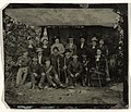 Portrait of a group of sixteen men and women on a hiking trip under makeshift stilted cloths, USA, c. 1890–1915