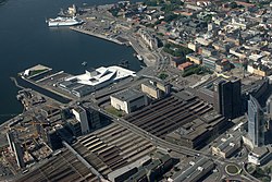 Aerial photo of Sentrum. The centre is located on the bottom-right side of the picture and the Waterfront with the Opera is located near the top. On the left side of the picture is Barcode. In the middle of the picture is the railway lines with the Oslo Central Station.