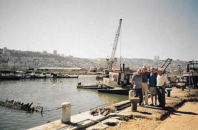 מנהל פרויקט המעגנה יהודה רותם שני משמאל, והדייגים משה רבה מימין, על רציף נמל הדיג בעת בניית מעגנת שביט, 1995