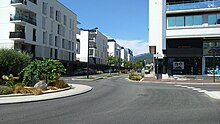 Photographie en couleurs d'une grande rue à partir d'un rond-point.