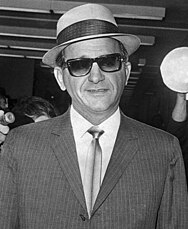 Giancana wearing jacket, tie, panama hat and a pair of dark sunglasses