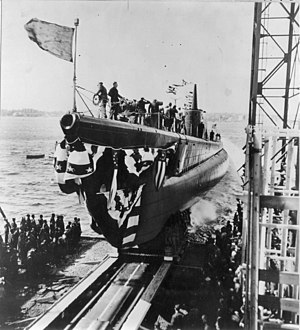 The crew of the Blackfish (SS-221) salute the colors as she is sliding down the launching ways at the Electric Boat Co.