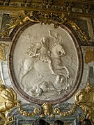 Luis XIV como emperador romano vencedor en la Sala de la Guerra del palacio de Versalles, estuco de Coysevox (1715).