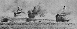 Photographie montrant trois chars égyptiens avançant à pleine vitesse sur une route du désert du Sinaï.