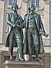 Photograph of the 1857 Monument to Goethe and Schiller in Weimar, Germany. The monument is based on Ernst Rietschel's bronze statue of the two men standing side by side, both looking ahead. They are in the contemporary dress of the era.