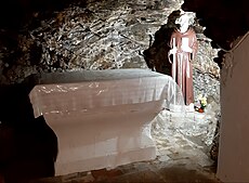 Autel et statue du saint dans la grotte.