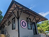 a picture of the current Sag Harbor freight house with a sign displaying the logo of the Kidd Squid Brewing Company on its facade