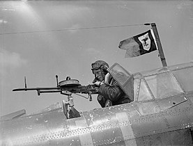 A sergeant air-gunner demonstrates a Vickers K gas-operated machine-gun.[m]