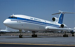 An Air Somalia Tupolev Tu-154, registration UR-85546, sitting idle on the taxiway at Sharjah International Airport. The livery is a blue stripe that spans the entire length of the plane, the line's location is just along the passenger windows. The tail fin is fully blue. Above the blue line is the text "Air Somalia", with a star next to it.