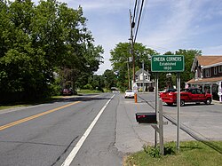Sign along New York State Route 9L indicating Oneida Corners.
